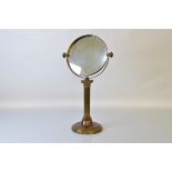 An early 20th century brass swivel mirror, 58cm tall.