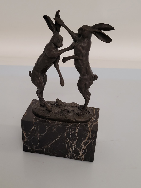 A contemporary bronze hare sculpture, of boxing hares, with foundry stamp Paris signed Nick, on