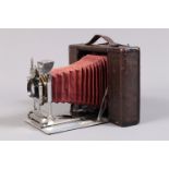 A Quarter Plate Folding Roll Film Camera, serial no 173604, possibly French, circa 1900, red