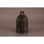 An antique Chinese bronze temple bell, 24cm high, with raised line and dot design and having