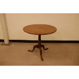 A Georgian oak wine table, 79cm diameter, tilt top on tripod base