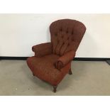 A second half 20th century armchair, with red mottled upholstery