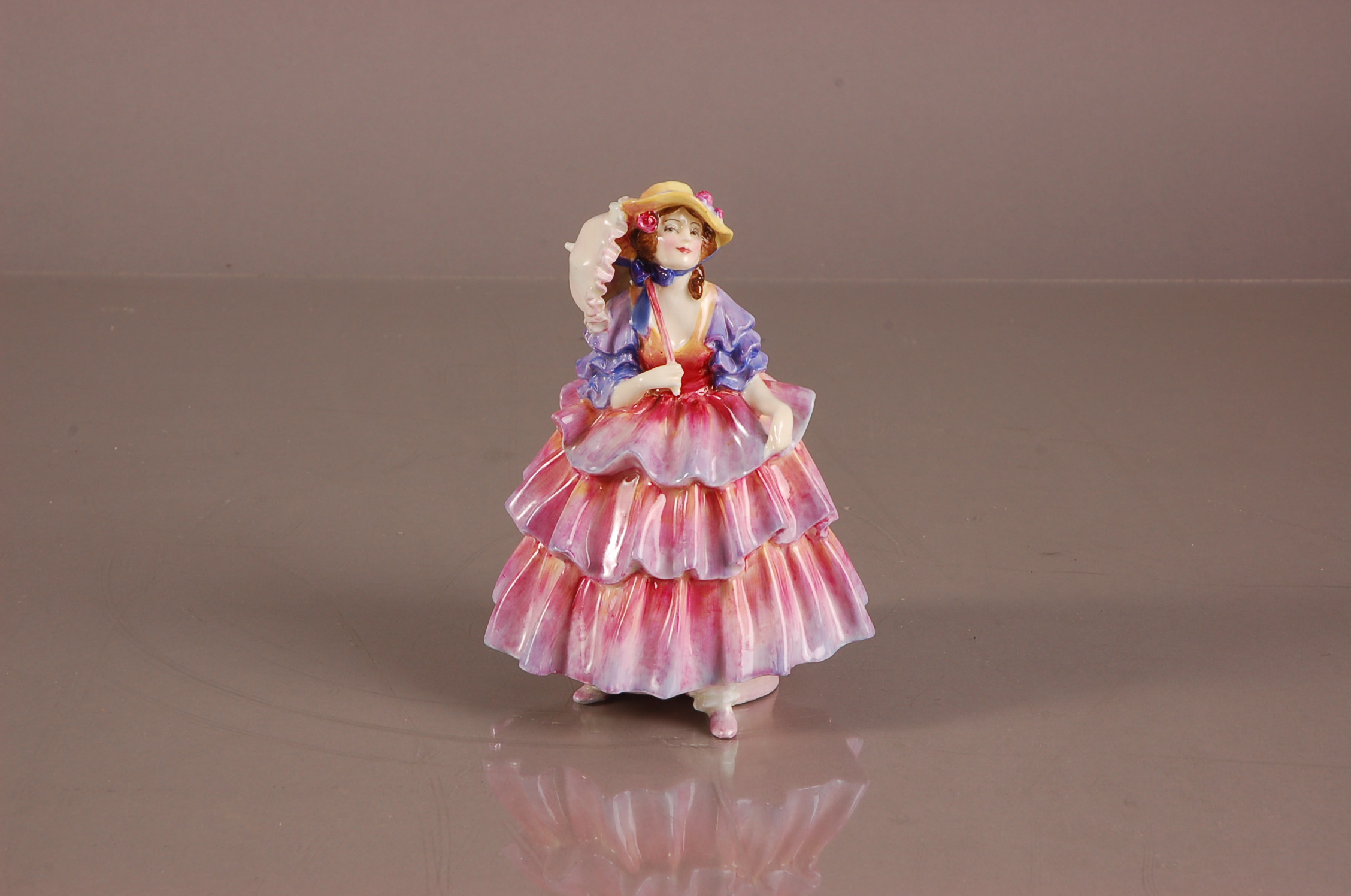 A c1935 Royal Doulton porcelain figure of a lady, HN 1579, The Hinged Parasol generally good