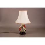 A modern Moorcroft pottery lamp base, Hibiscus pattern in bright colours, with shade