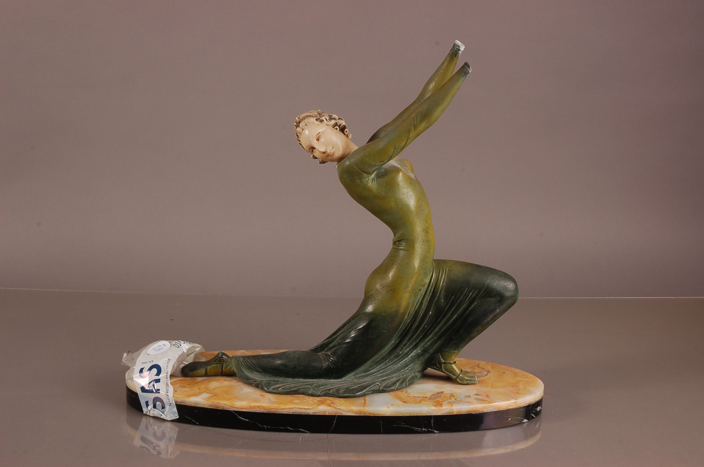 An Art Deco style spelter figure, AF, modelled as a young lady in green dress, hands loose and