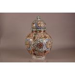 A large Middle Eastern decorative jar and cover, AF, 58cm high, the tin glazed earthen ware base and