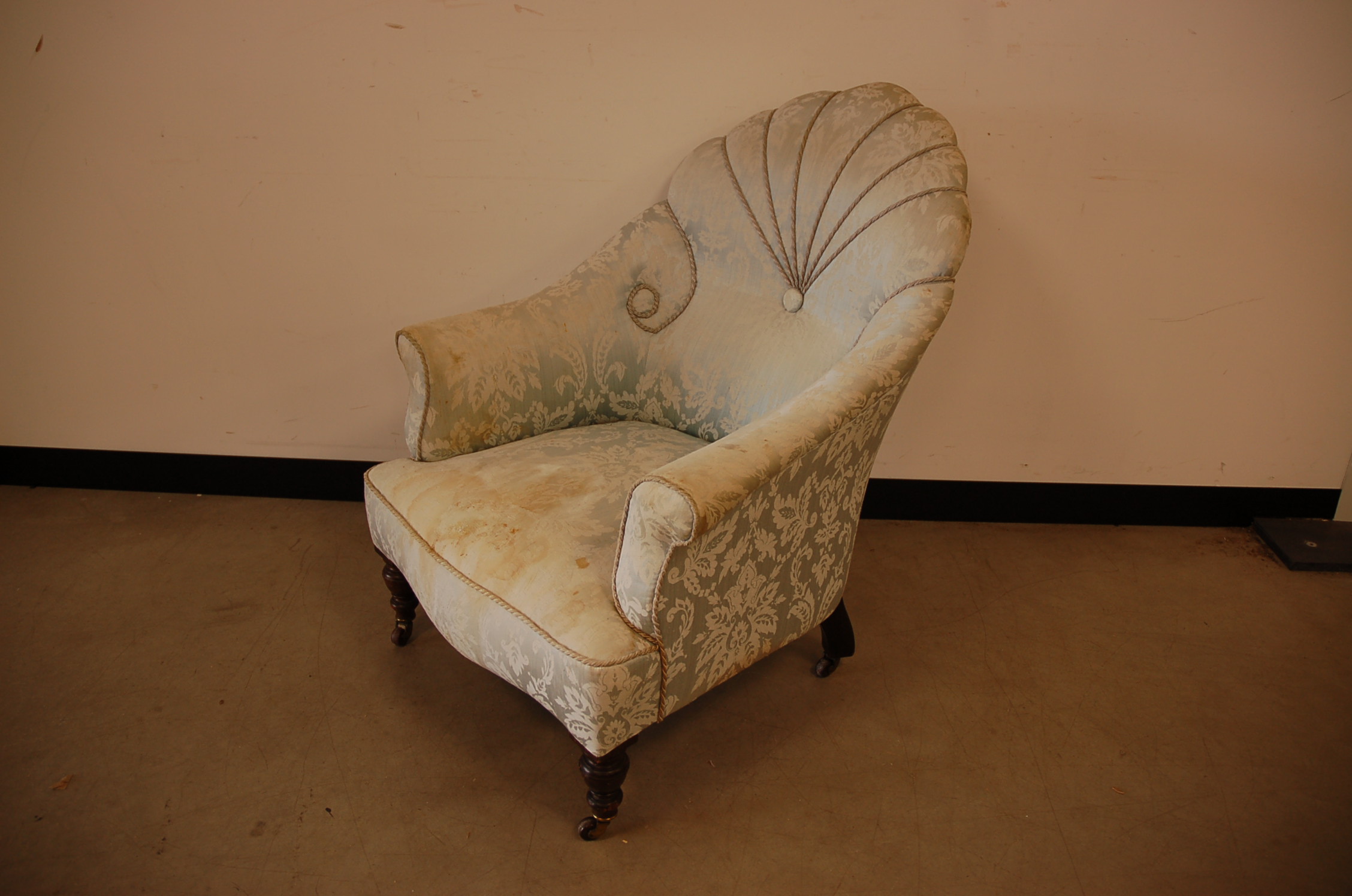 A Victorian and later armchair, with mahogany legs on casters, upholstery in poor condition