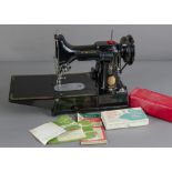 An electric boxed Singer sewing machine, with various feet and accessories, and an original