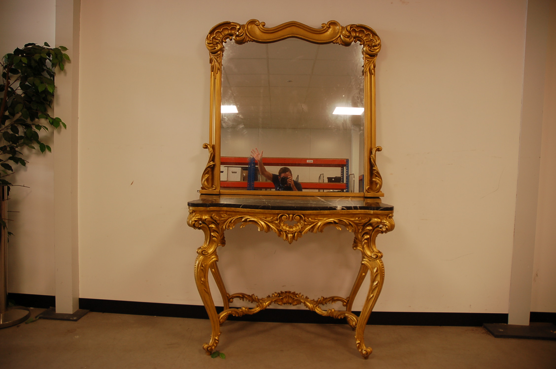 A second half 20th century gilt console table and mirror, the rococo style ornate base with shaped