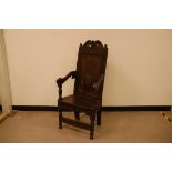 A 17th century and later joined hall chair, carved top rail with later inserted small head