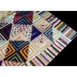 A silk log cabin patchwork quilt, 1870s, composed of blocks of moire, grosgrain and other silks,