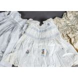 A collection of baby clothes, early 20th century, including smocked 1920s dresses and cotton