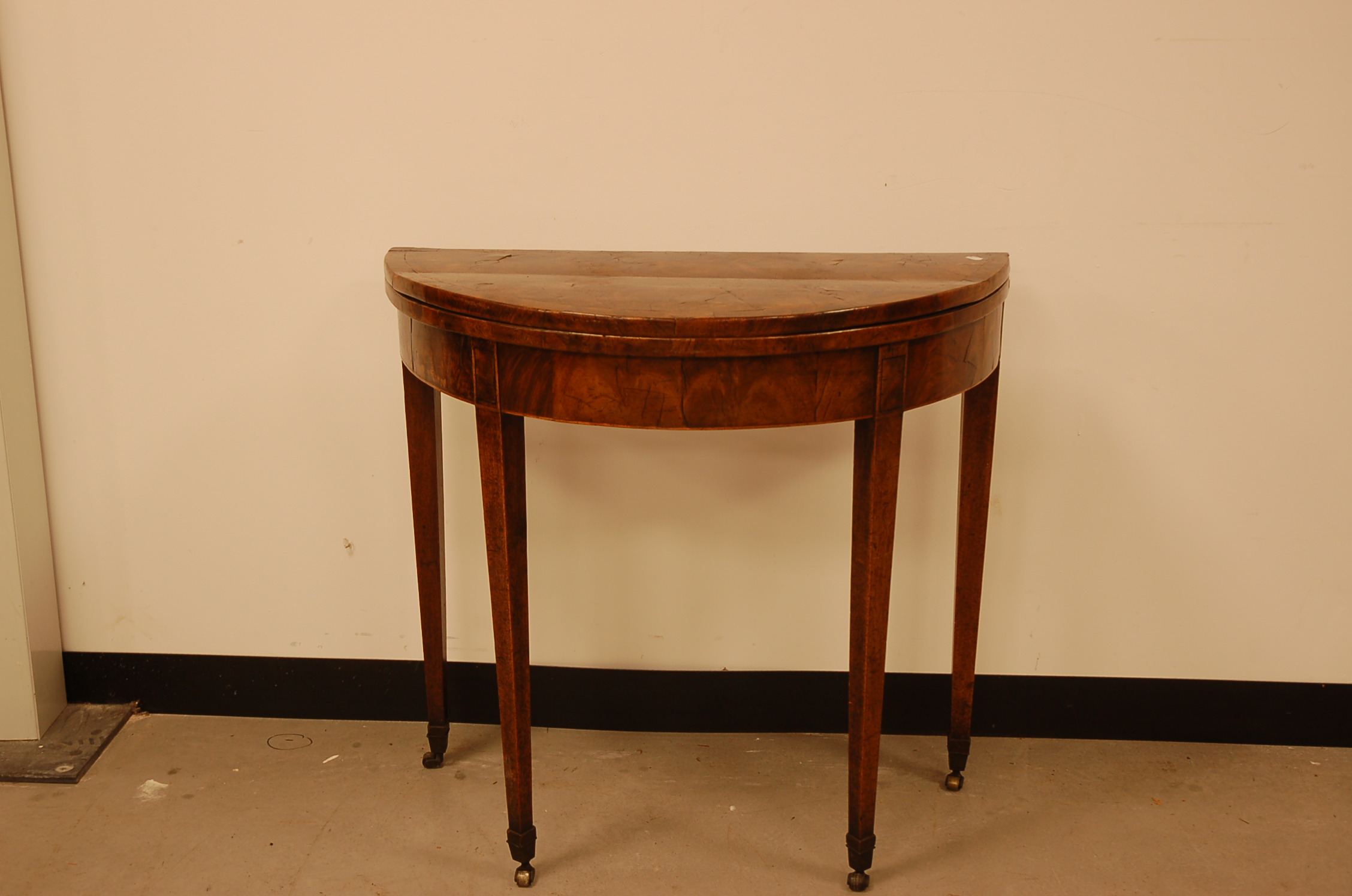 A 19th century mahogany and inlaid demi-lune card table, 78cm wide, on casters