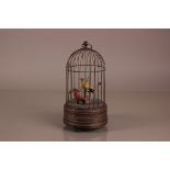 A late Victorian bird cage automaton, 27cm high, with yellow and red bird in the cage, appears to