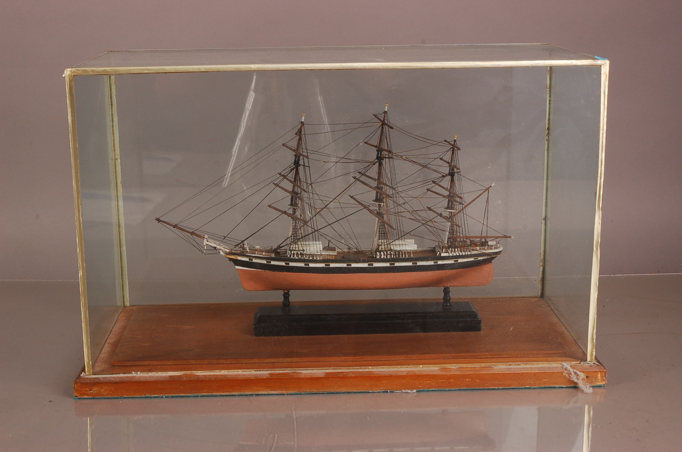 A mid 20th century model of a ship, in glass case with wooden base, 53.5cm wide