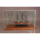 A mid 20th century model of a ship, in glass case with wooden base, 53.5cm wide