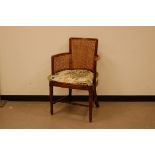 An early 20th century chair, with rattan back and sides, later cushion, some evidence of woodworm