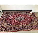A large Middle Eastern woollen carpet, 305cm by 204cm, medallion design,bearing label