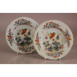 A pair of lat 18th or early 19th century French faience plates, 24cm diamter, some chips