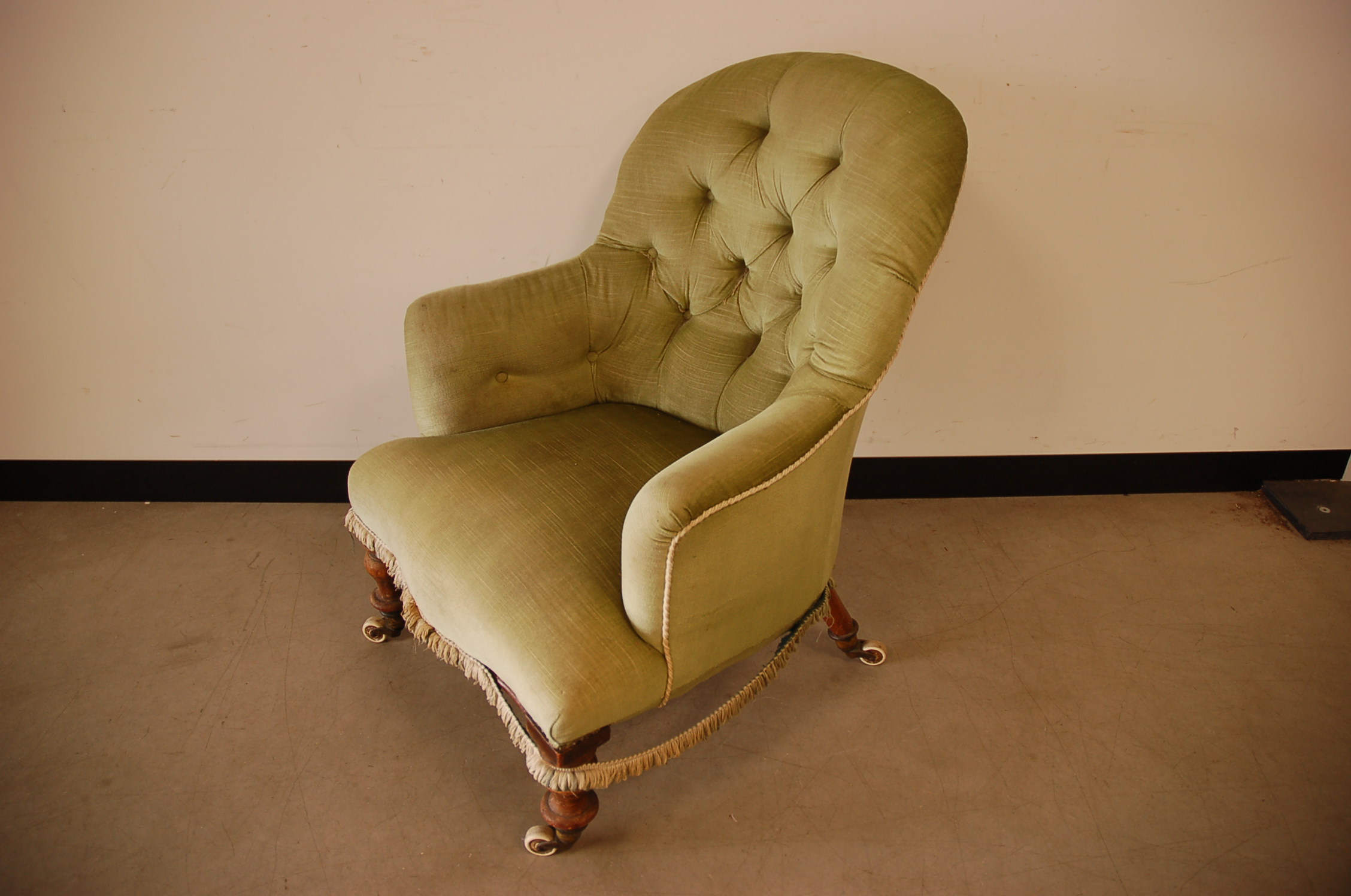 A Victorian and later armchair, turned front supports and sabre back legs on porcelain casters, with