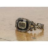 A William IV memorial ring, in black enamel with plaited hair panel (missing top), feathered and