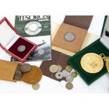 A collection of World coins and medallions, including a 1985 Mexico World Cup coin on card, a set of