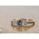 A three stone sapphire and diamond dress ring, the circular cut sapphire flanked by a pair of