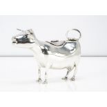 A 20th century continental white metal reproduction of a cow creamer, three marks to underside, 5.85