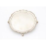 A c1960s silver salver from A.T.C, 11.2 ozt, with shaped rim on three scroll supports, marks worn