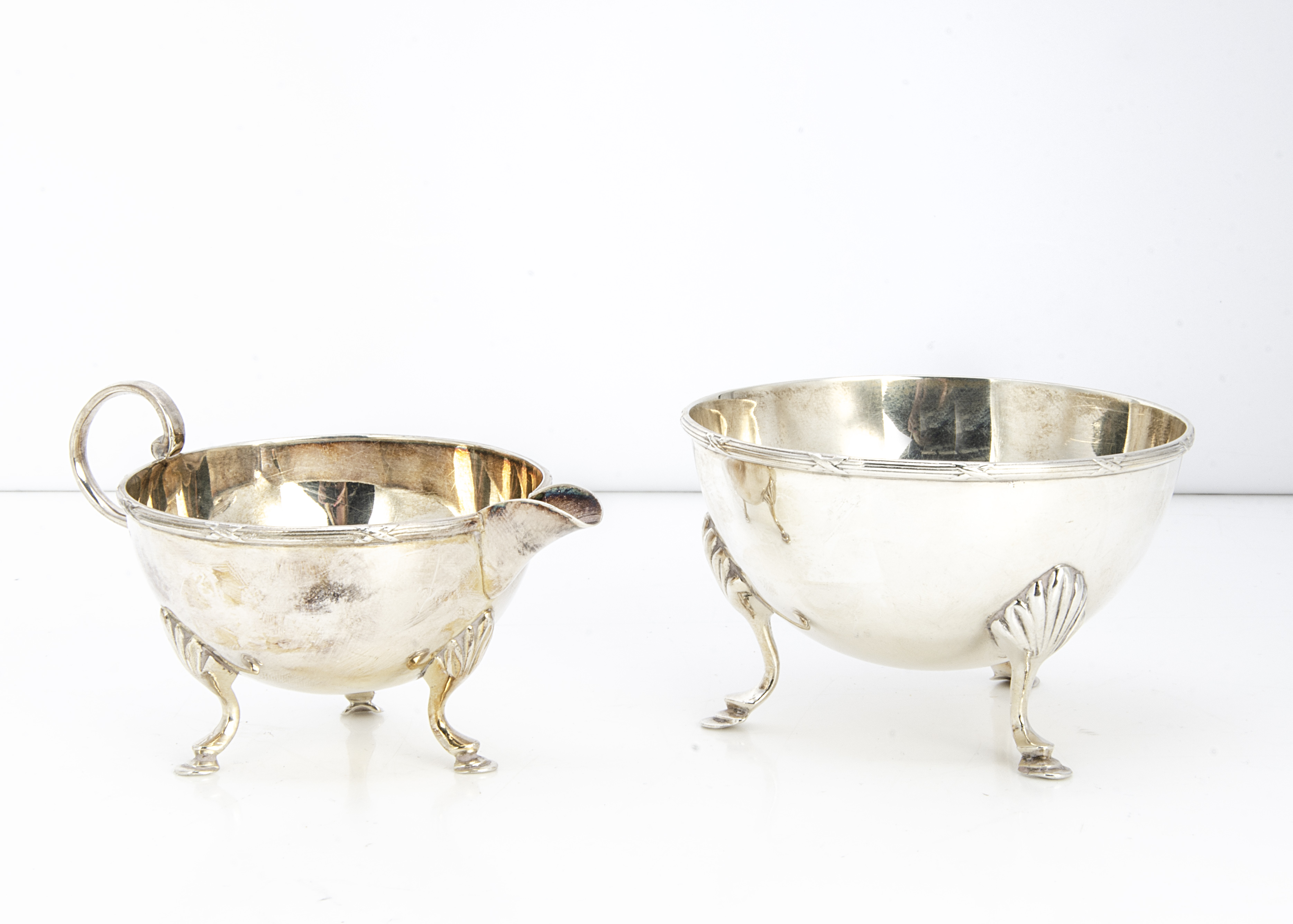 A George V silver sugar basin and milk jug from Mappin & Webb, 5.48 ozt, each on three hoof