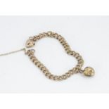 A 9ct gold flattened curb link charm bracelet, with one charm of a seashell, 18cm, 9.6g