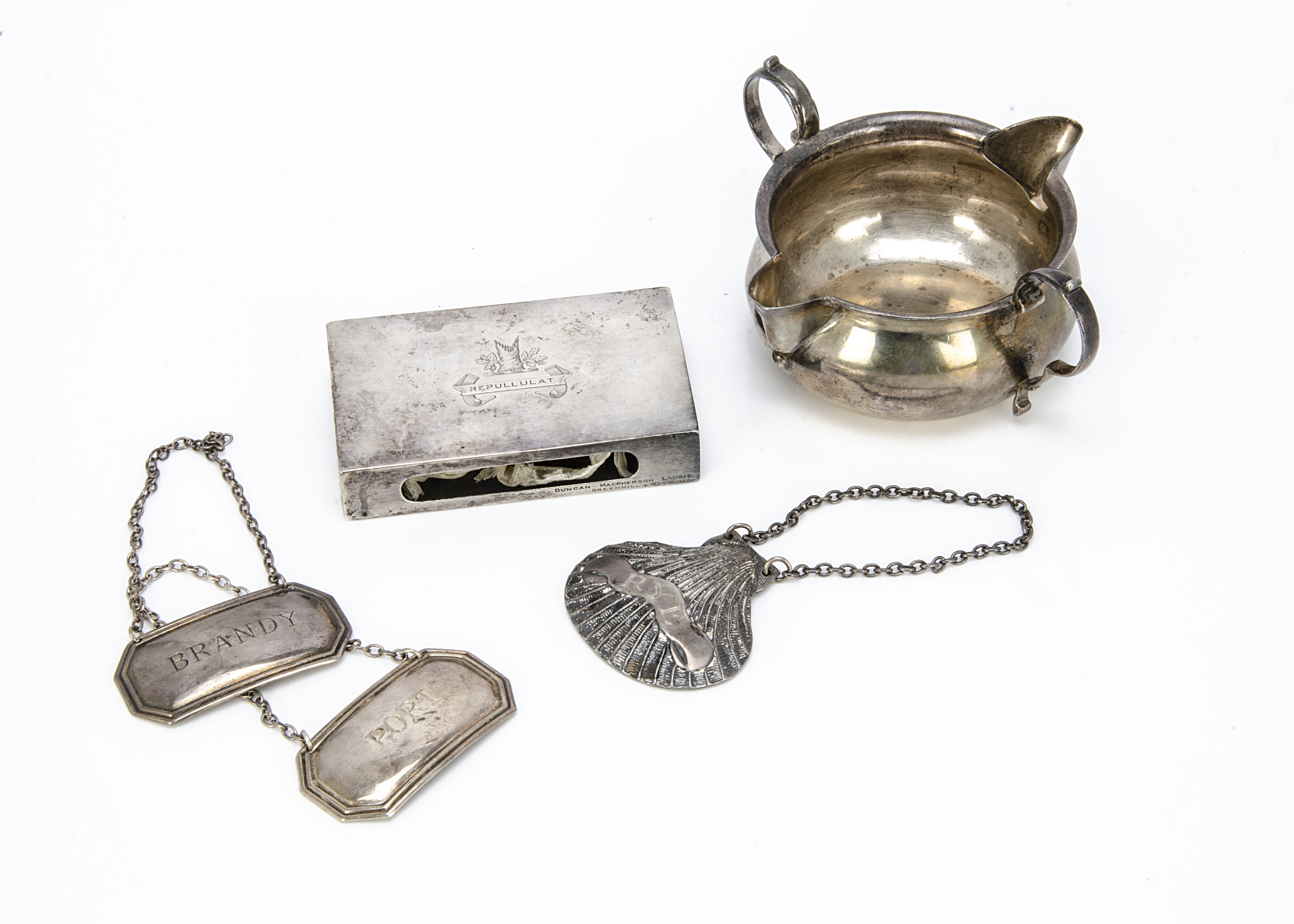 Five items of silver, including a twin lipped circular jug, a matchbox holder, a pair of decanter