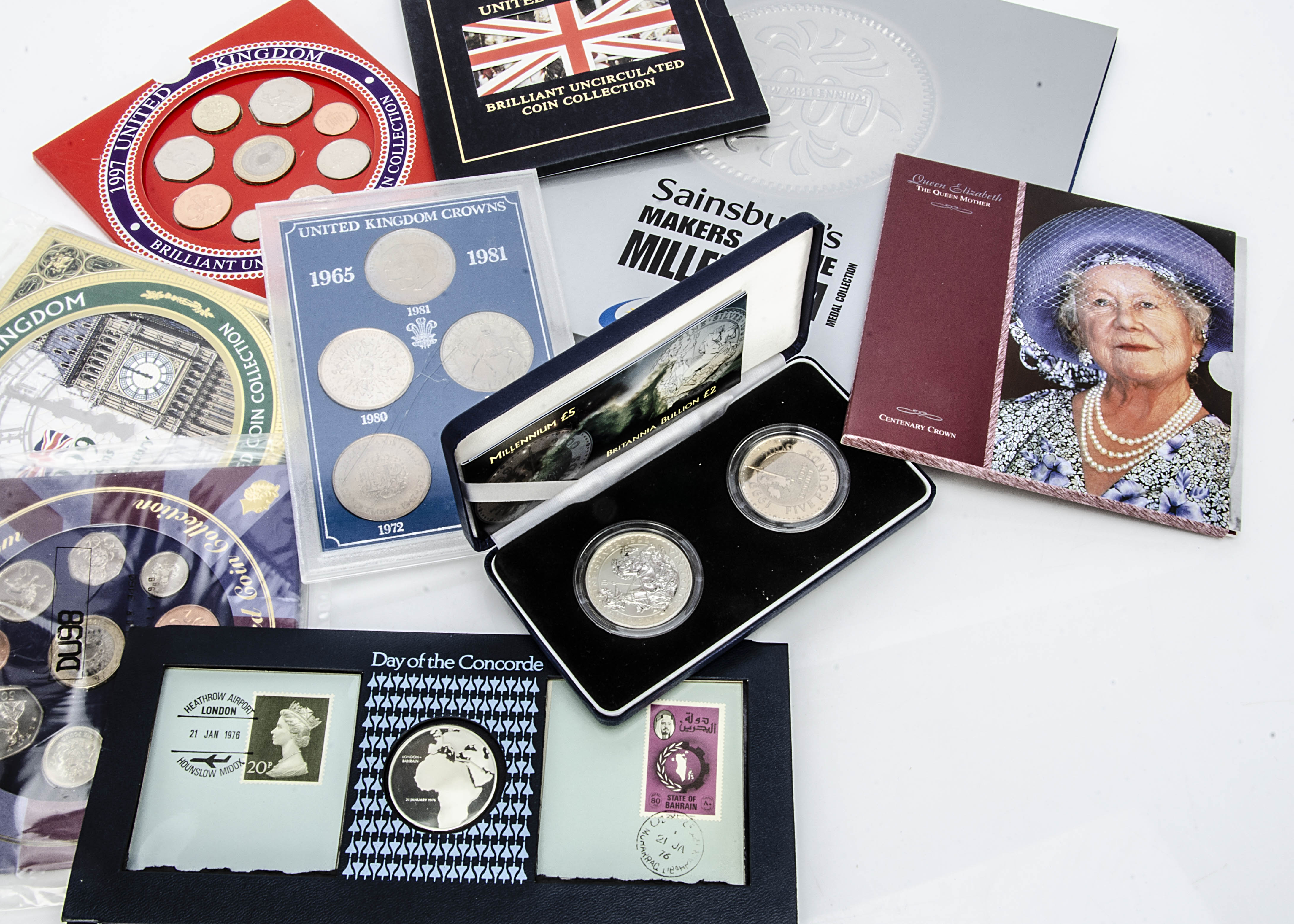 A collection of modern uncirculated coins, including a Millennium £5 and Britannia Bullion £2 set,