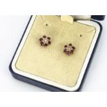 A pair of diamond and ruby studs, in yellow metal mounts and backs, cased