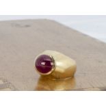 A continental gold and ruby lady's dress ring, the cabochon ruby in raised collar setting on a