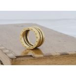 A continental yellow metal Bulgari style ring, the expandable ring marked 750, ring size K 1/2, 10g