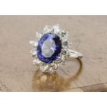 A contemporary tanzanite and diamond cluster ring, the oval claw set mixed cut tanzanite