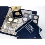 A collection of British coins, presented in an A4 folder and several blue collectors' folders,
