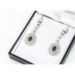 A pair of emerald and diamond Art Deco style drop earrings, pear shaped emeralds surrounded by