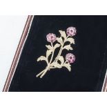 A 9ct gold ruby floral spray brooch, the gold engraved leaves and stems supporting ruby set flower