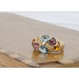 A continental yellow metal multi gem set and diamond Tiffany style dress ring, the cabochon gems and
