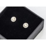 A pair of diamond cluster studs, the central brilliant cut surrounded by a bezel of round cuts all