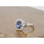 An Edwardian style tanzanite and diamond cluster ring, the oval mixed cut tanzanite surrounded by