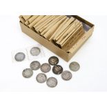 A collection of British coins, sorted into paper envelopes by monarch with examples from Victoria to