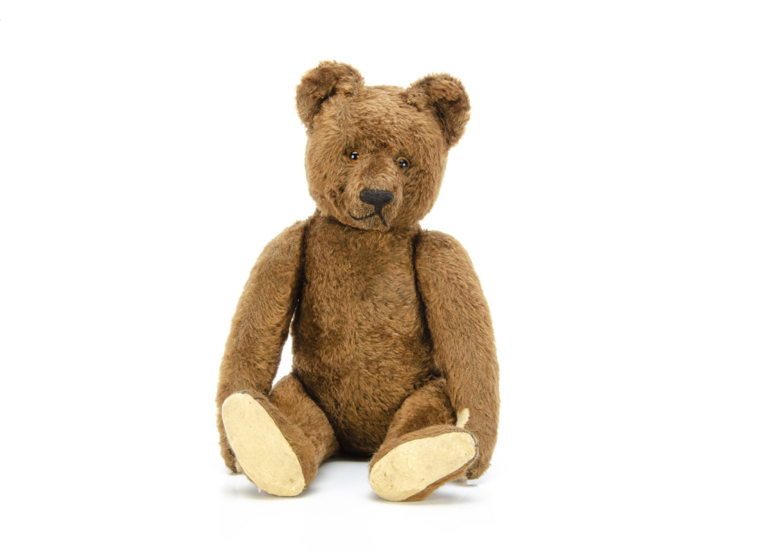 A 1920s Bing brown mohair teddy bear, with clear and black glass eyes, pronounced muzzle, black