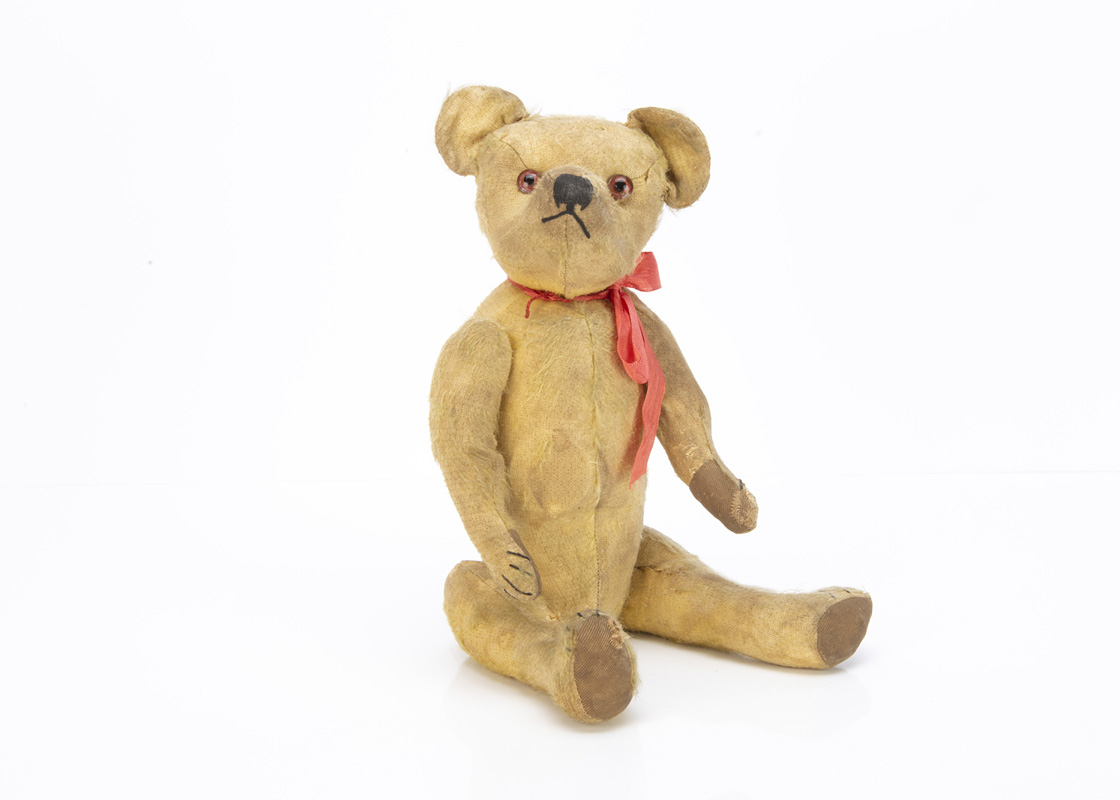 An early British teddy bear circa 1920, with golden mohair, clear and black glass eyes with brown