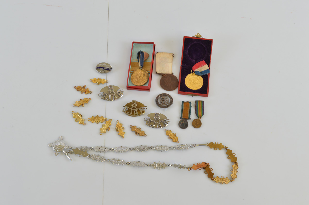 A collection of assorted medals and badges, including a WW1 for Services Rendered badge, a pair of