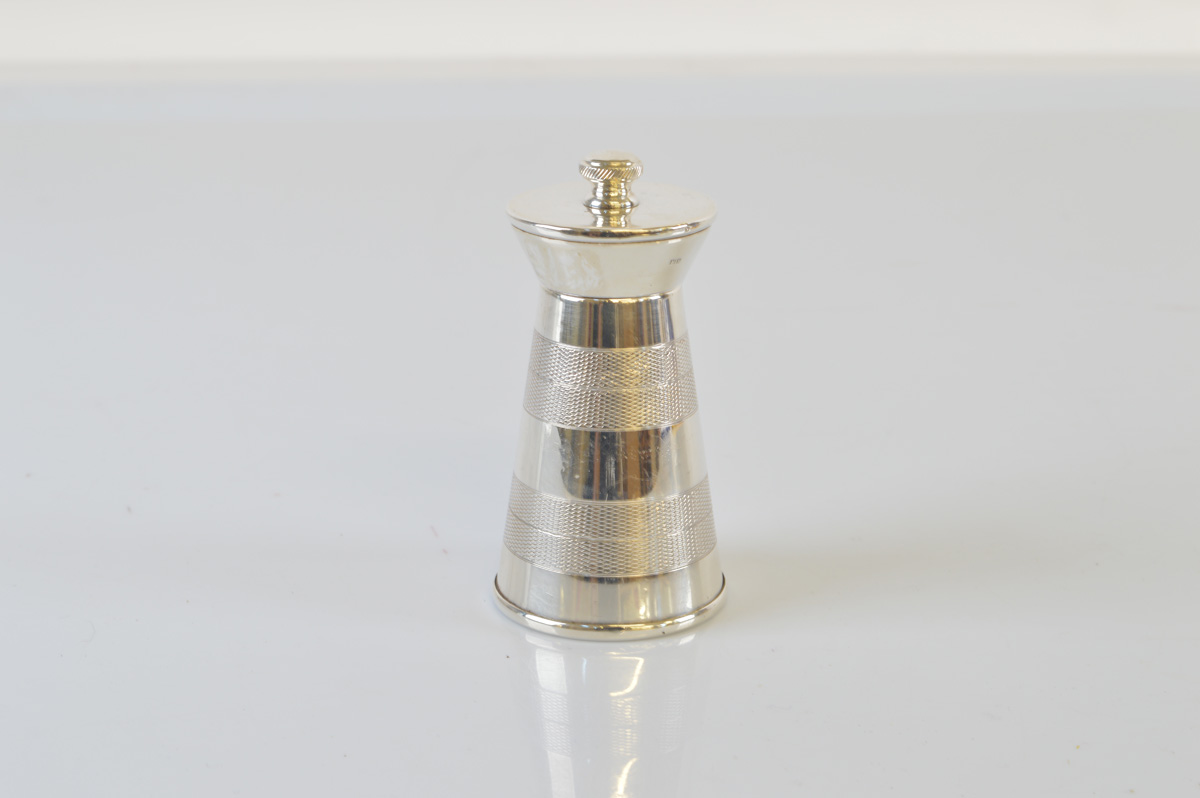 A contemporary silver pepper mill, in milk churn form, with banded engine turned decoration. 10cm