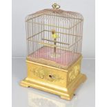 A 19th-century singing bird in cage, the rectangular domed cage on giltwood base with applied