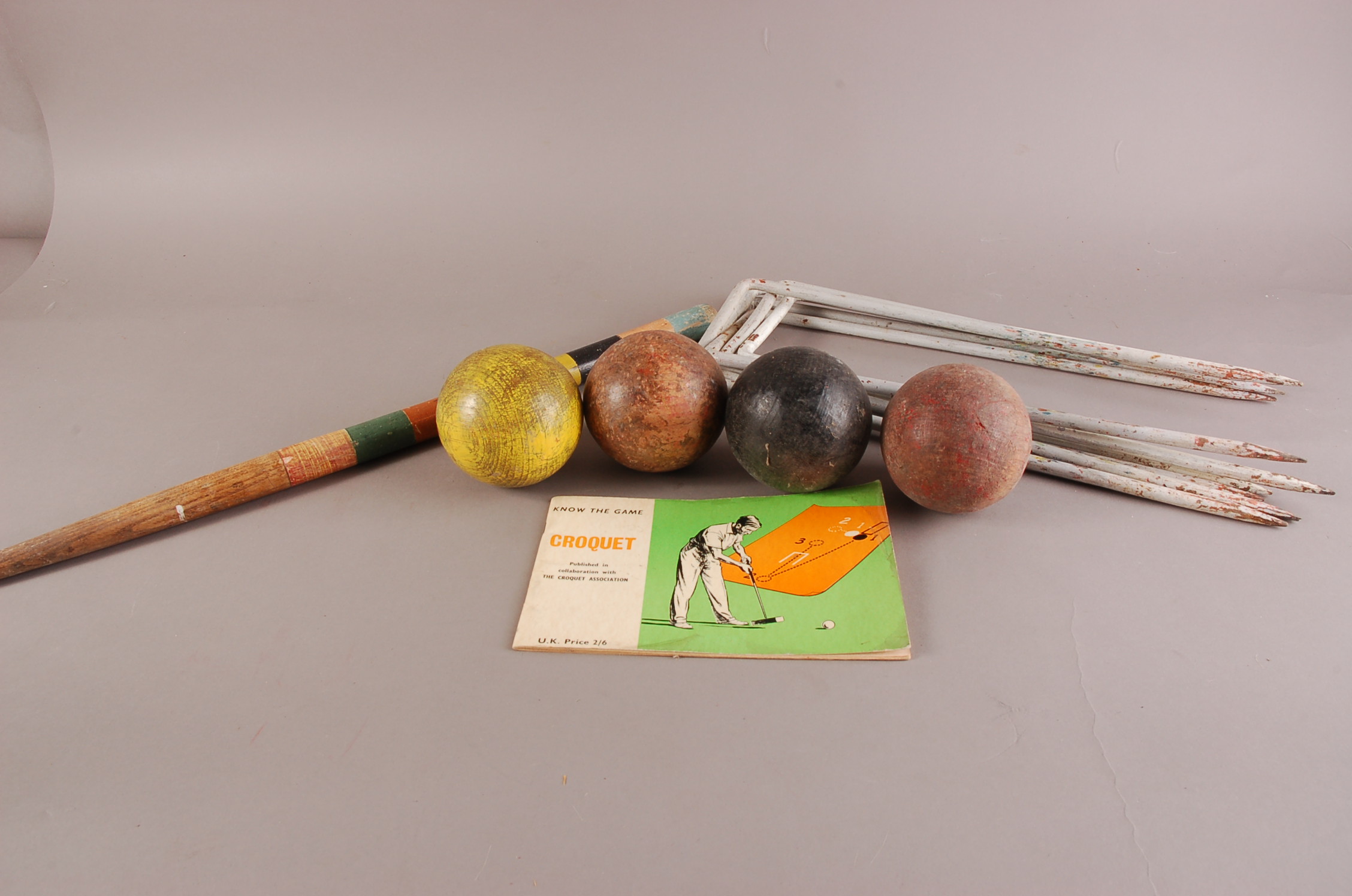 A vintage Croquet set, comprisng four mallets, four balls, six cast iron hoops, coloured centre